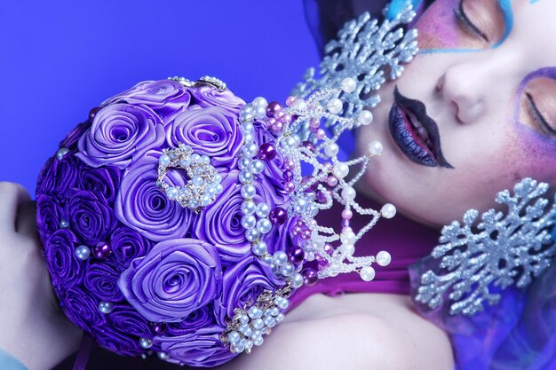 Woman with creative make up holding a bouquet of jewelry