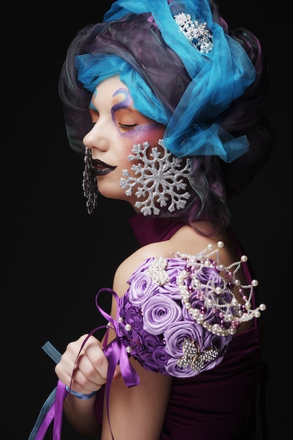 Woman with creative make up holding a bouquet of jewelry