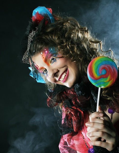 Woman with creative makeup in doll style with candy