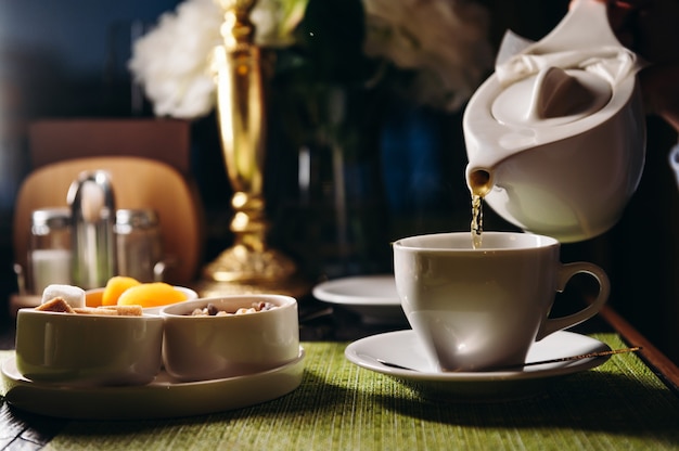 A woman with a cup of hot tea in her hands sits in the restaurant The girl drinks aromatic tea Enjoy the moment take a break