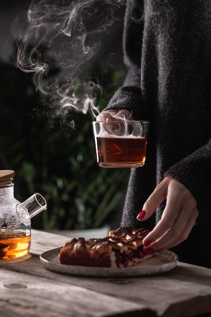 Woman with cup of hot tea with cranberry pie