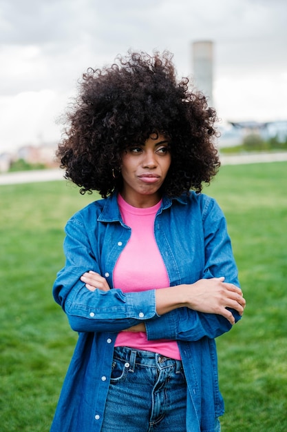 Woman with curly afro hair looking disgusted outdoors in a park lifestyle