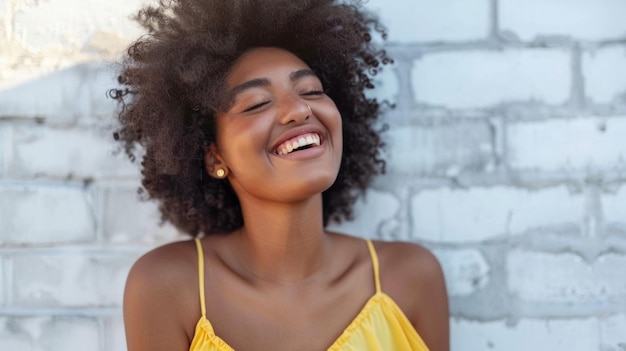 A woman with curly hair is smiling and wearing a yellow dress