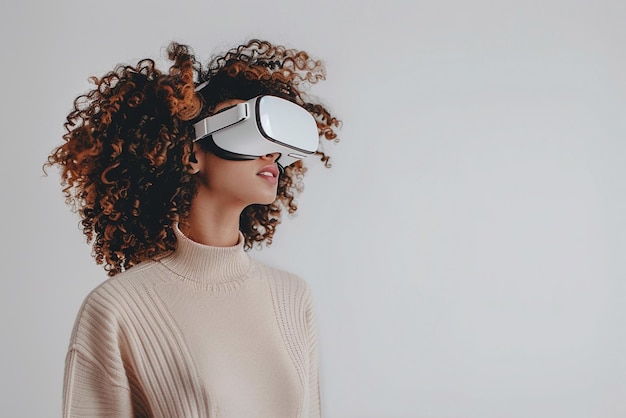 Woman with curly hair looking around in virtual reality goggles in white room