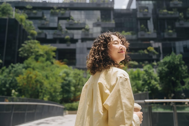 a woman with curly hair and a yellow dress is standing in front of a building