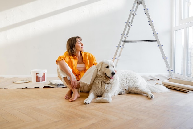 Woman with dog in room while making repairment in apartment