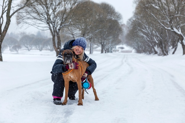 Woman with a dog on a walk in snowy weather