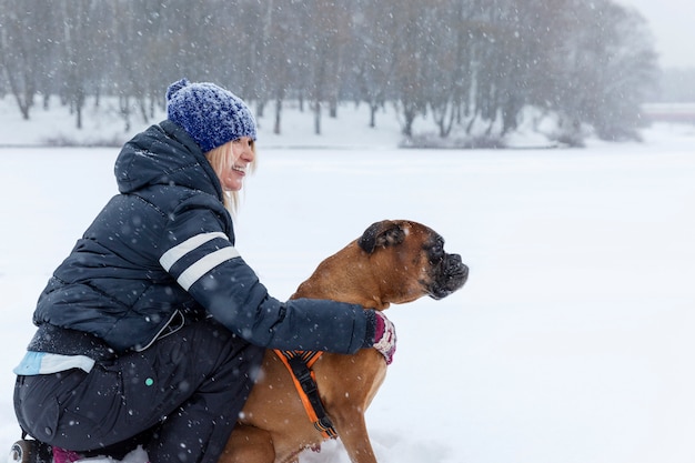 Woman with a dog on a walk in snowy weather