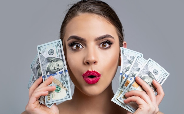 Woman with dollars in hand Portrait woman holding money banknotes Girl holding cash money in dollar banknotes Woman holding lots of money in dollar currency Luxury beauty and money concept