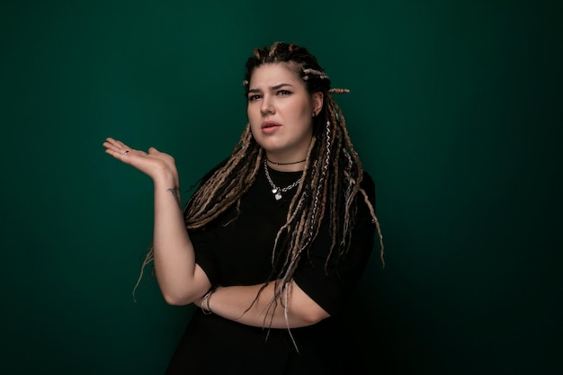 Woman with dreadlocks in front of green background