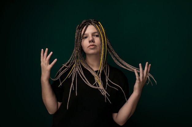 Woman with dreadlocks in front of green background