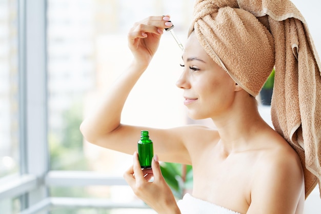 Woman with a drops of cream on her face