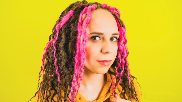 Woman with dyed hair Portrait of young woman with brown eyes looking at camera isolated on yellow background