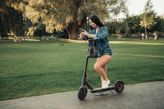 Woman with electric scooter on city street