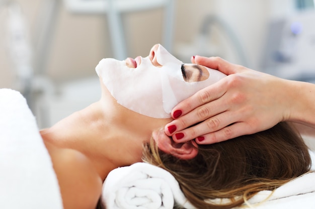 woman with facial mask in beauty salon