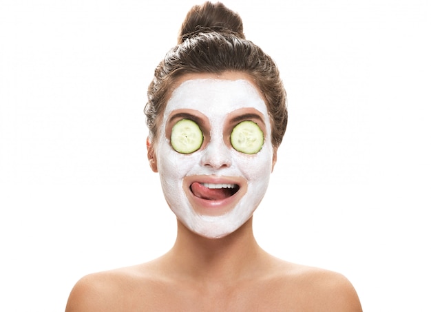 Woman with facial mask and cucumber slices on her eyes