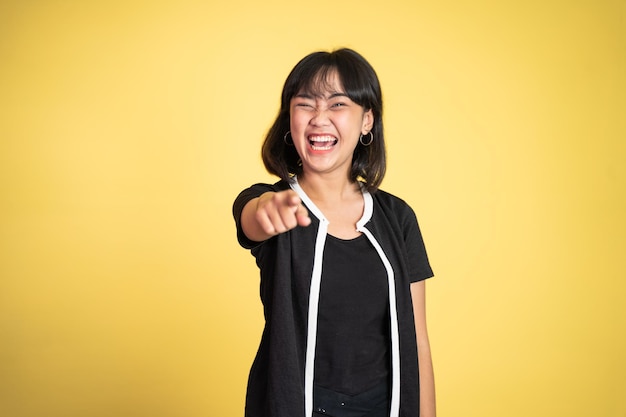 Woman with finger pointing at frong and laughing at something