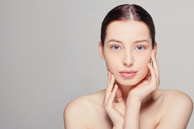 woman with fresh clean skin that touches her face with both hands.