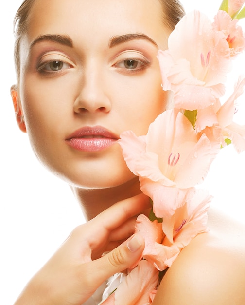 Woman with fresh face holding gladiolus flowers in her hands