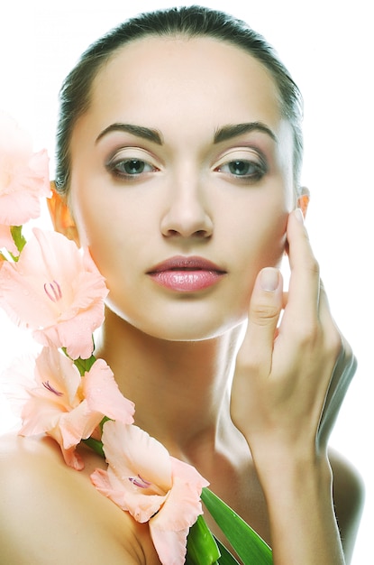 Woman with fresh face holding gladiolus flowers in her hands