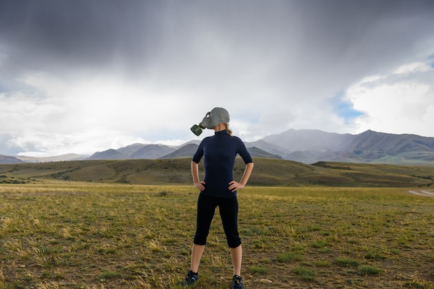 Woman with gas mask in the mountains