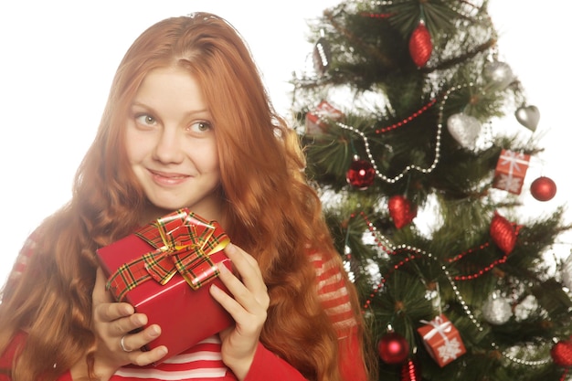 Woman with gift box and christmas tree