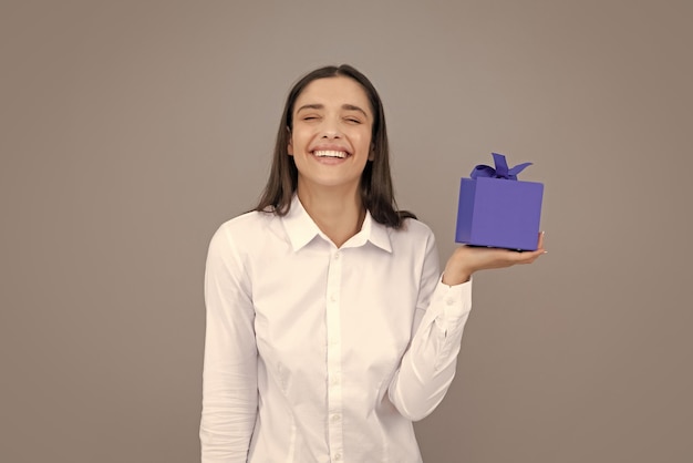 Woman with gift Portrait of excited young girl holding gift box isolated grey background Pretty girl with present