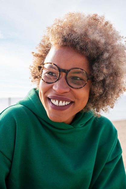 Woman with glasses and afro hair smiling happy