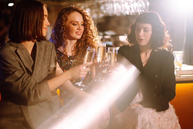 Woman with glasses of champagne at a party. Women friends ?elebrating winter holidays together.