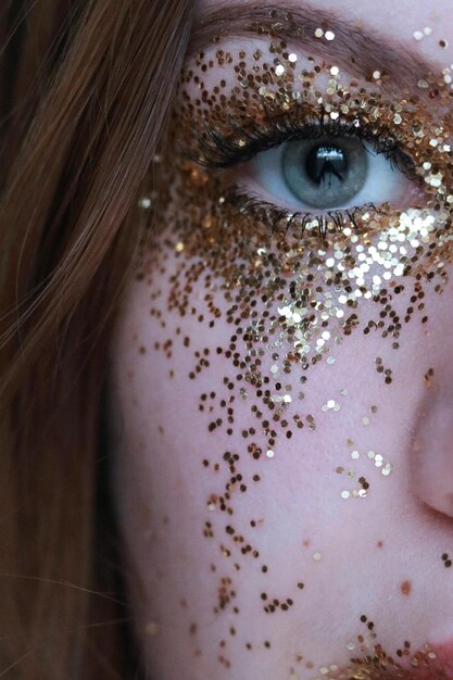 Photo a woman with a gold glitter eye makeup and a blue eye