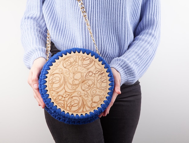 Woman with hand made bag on gray background