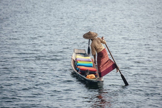 A woman with handcrafted colorful lotus fabrics on her boat in In Dain Khone village, on Inle Lake, Myanmar. 