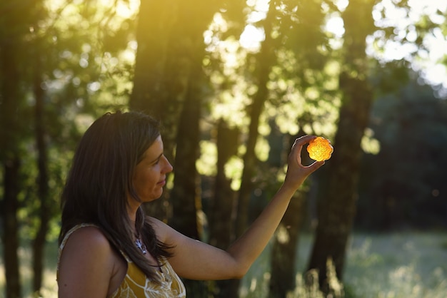 Woman with handmade soap backlit in forest sunset