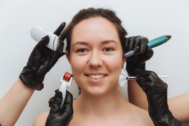 A woman with the hands of several therapists with cosmetology devices near her face a woman needs skin care skin care concept photo