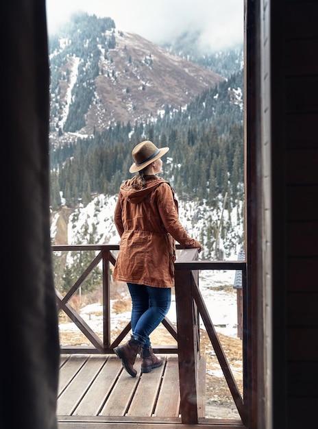 Woman with hat at cabin in the woods