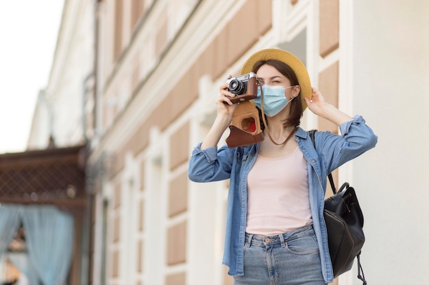 Woman with hat and face mask taking pictures