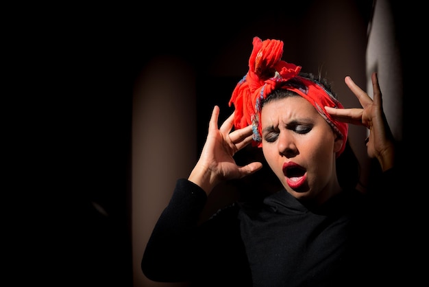 Woman with headscarf black background with headache