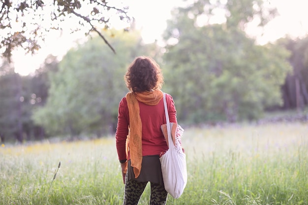 Woman with her back to nature with her yoga tools