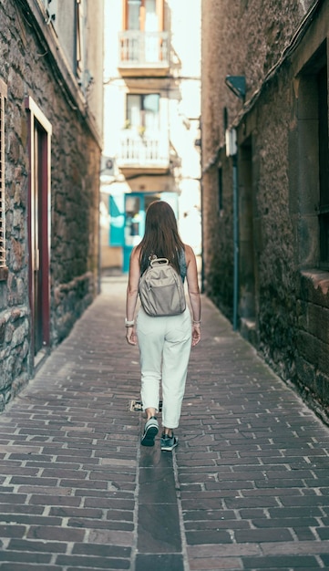 Woman with her back turned walking down a street in an old village