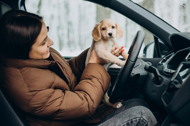 Woman with her cute dog sitting in car