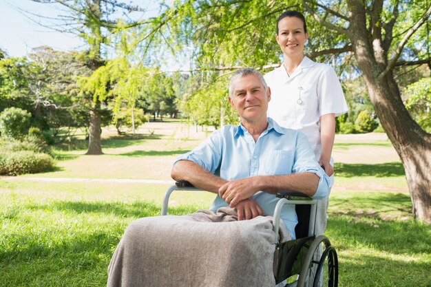 Woman with her father sitting in wheel chair at park