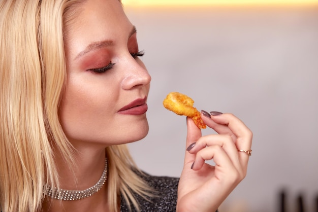 A woman with her hands eats a large appetizing shrimp Selective focus