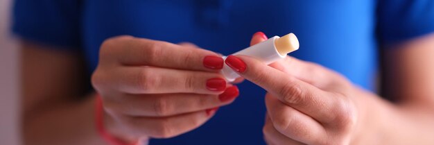 Woman with hygienic lipstick in hands closeup