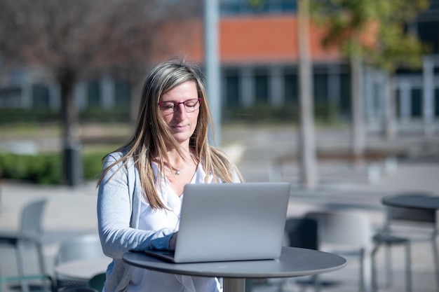 Woman with laptop outdoors in an office space