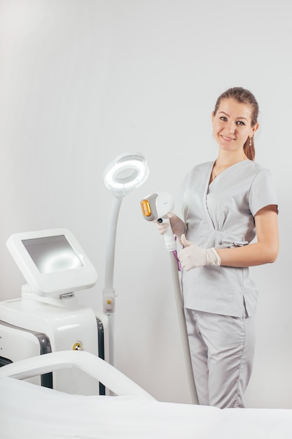 Woman with a laser hair removal machine