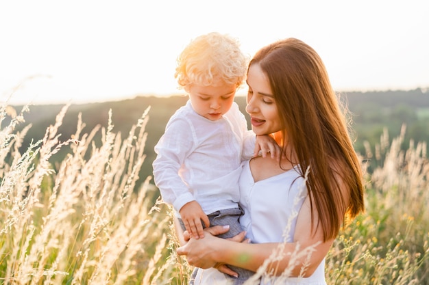 Woman with little boy stands in the middle of field