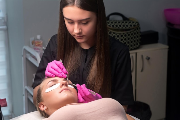 Woman with long lashes in a beauty salon. Eyelash extension procedure.