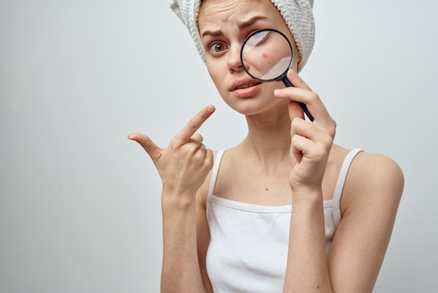 Photo woman with a magnifying glass in hand skin problems closeup