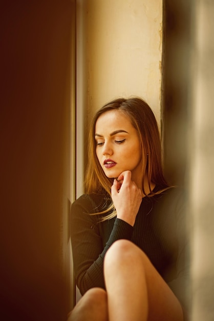 Woman with makeup on pretty face sit at wall Woman relaxing alone Enjoying time at home