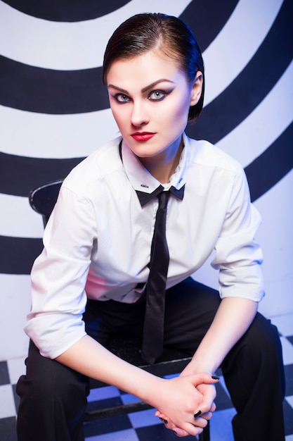 Woman with makeup wearing a white shirt and tie